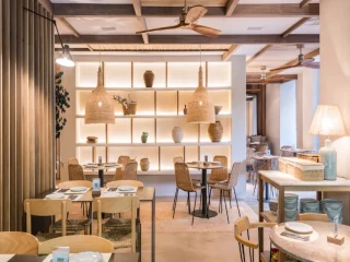 Interior de un restaurante Saona con diseño mediterráneo, materiales naturales y ambiente cálido y acogedor.