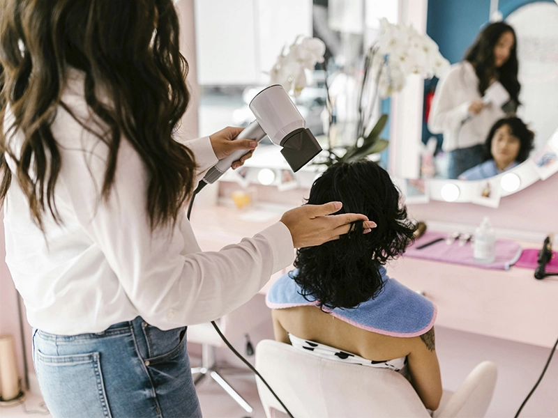 Peluqera cortando el pelo de una cliente dentro de un local franquiciado de Jean louis David