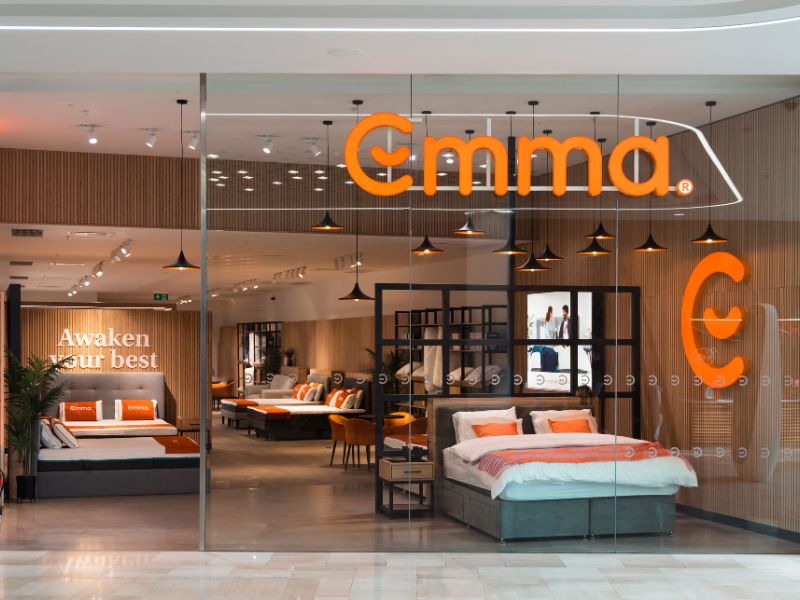 Tienda física de Emma Colchón en centro comercial, mostrando camas, colchones y decoración moderna.