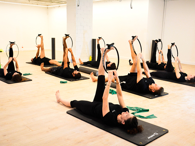 Interior de un local de Pilates 10 con gente haciendo deporte