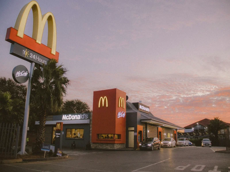 Restaurante McDonald’s con autos en el drive-thru, símbolo del crecimiento y expansión de la franquicia en España.