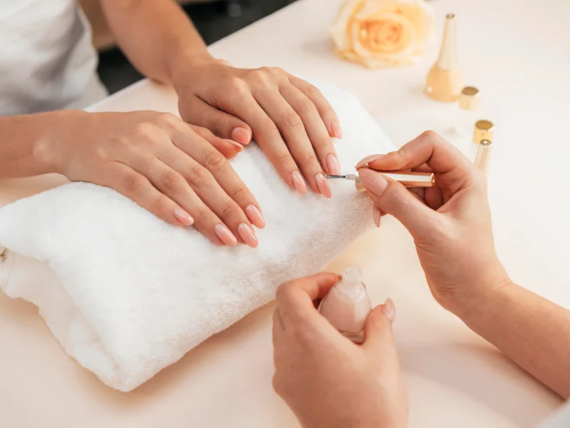 Aplicación de esmalte en un centro de estética especializado en manicura, ejemplo de servicios ofrecidos por franquicias de uñas en España