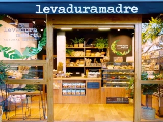 Fachada de la panadería artesanal Levadura Madre Natural Bakery con variedad de panes artesanales y productos naturales en exhibición.