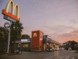 Restaurante McDonald’s con autos en el drive-thru, símbolo del crecimiento y expansión de la franquicia en España.