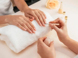 Aplicación de esmalte en un centro de estética especializado en manicura, ejemplo de servicios ofrecidos por franquicias de uñas en España
