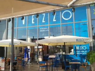 Fachada del restaurante Vezzo en el centro comercial Lagoh de Sevilla, con terraza al aire libre y diseño moderno del grupo FoodBox.