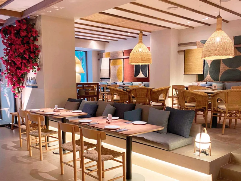 Interior de un restaurante Saona con decoración mediterránea, diseño acogedor y ambiente de franquicia de restauración moderna.