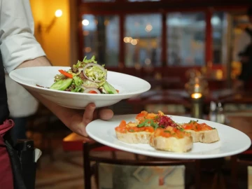 Camarero sirviendo platos en una franquicia de restaurantes