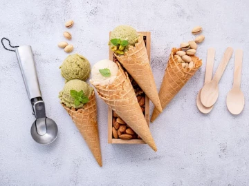 Conos de helado artesanal de pistacho y vainilla sobre fondo claro, imagen representativa de franquicias de heladerías artesanales y gourmet